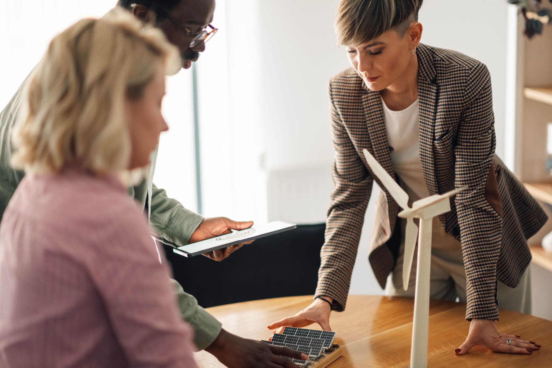 Engineers developing project with solar panel and wind turbine models